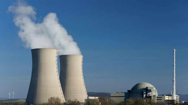 Das deutsche Kernkraftwerk Grohnde mit zwei dampfenden Kühltürmen.