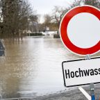 Hochwasser an einem deutschen Fluss mit dem einem Warnschild