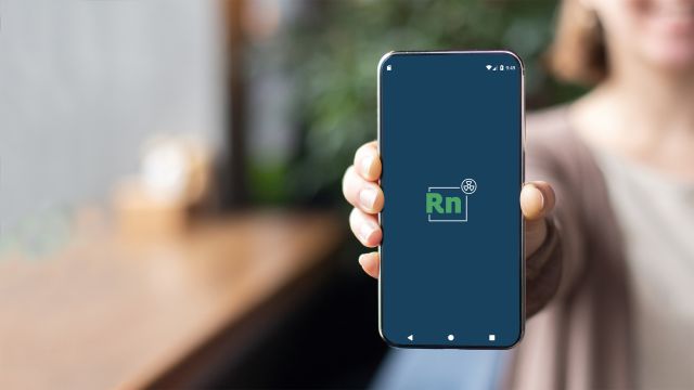 Eine Frau hält ein Handy in der Hand, auf dem die neue GRS-App Radon-Dosis zu sehen ist